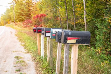 Row of old metal mailboxes along a country road in autumn. Ontario, Canada.