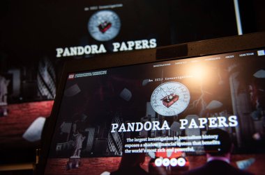 Kyiv, Ukrayna, 07 Ekim 2021. Bu resimde Pandora Papers logosu mobil ekran önplanı ve bilgisayar ekranı arka planında. 