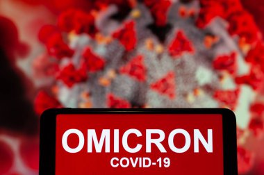 Bu resimde, bir telefon ekranında Omicron COVID-19 yazan bir metin gösteriliyor..