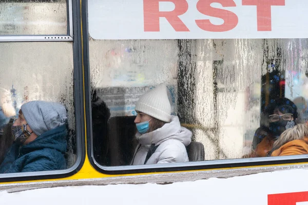 Lviv, Ukrayna, 7 Aralık 2021. Yüz maskeli insanlar otobüste otururlar..