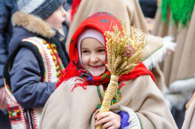 Lviv, Ukraine, 6 january 2022. Ukrainian little girl with wheatin hands during parade. Ukrainians sing Christmas carols as they carry decorated stars of Bethlehem and sheaves of wheat in their hands during. Ukrainian believers celebrate the Orthodox 