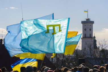 Lviv, Ukrayna, 19 Şubat 2022. Ukrayna ve Kırım Tatar bayrağı, Ukrayna-Rusya sınırındaki gerginlikler nedeniyle, Lviv şehir merkezindeki Birleşme Yürüyüşü sırasında.