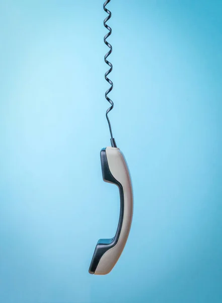 Ένα Γκρι Ακουστικό Τεντωμένο Τηλεφωνικό Καλώδιο Μπλε Φόντο Εξοπλισμός Επικοινωνίας — Φωτογραφία Αρχείου