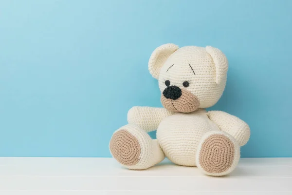 Een Mooie Kleine Gebreide Teddybeer Een Witte Tafel Een Blauwe — Stockfoto