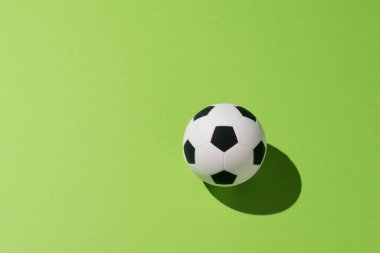 Yeşil arka planda parlak ışıkta futbol topu. Popüler top oyunu konsepti.