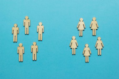 Mavi arka planda iki grup erkek ve kadın figürü. Cinsiyete göre ayrılmış iki grup insan..