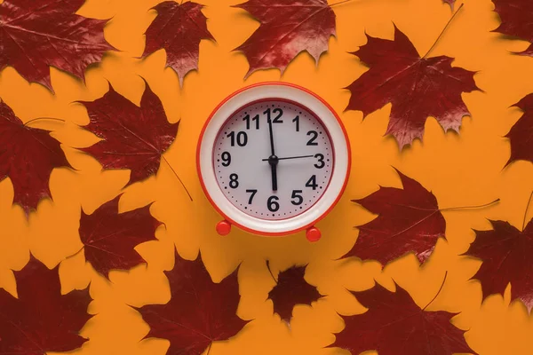 Красные Осенние Кленовые Листья Красный Будильник Оранжевом Фоне Осенняя Концепция — стоковое фото