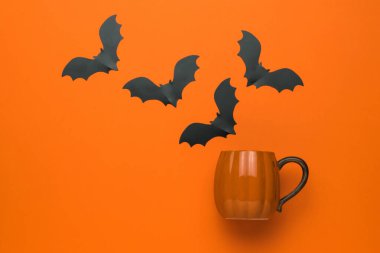 Turuncu arka planda turuncu bir çemberden uçan yarasalar. Popüler bir Ekim tatili. Düz yatıyordu.