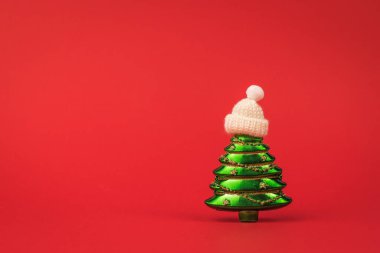 Örgü şapkalı yeşil bir Noel ağacının yaratıcı görüntüsü. Mesaj için yer var. Noel kutlaması için hazırlık.