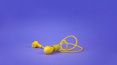 Mor arka planda uzun sarı bir kablo üzerinde sarı bir ampul. Minimalizm. Enerji ve iş kavramı.