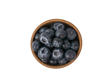 Beyaz arka planda yaban mersinli ahşap bir kasenin üst görüntüsü. Lezzetli ve sağlıklı dut.