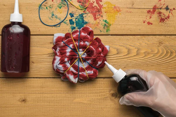 Kız ftubolka 'ya boyalı kravat şeklinde spiral desen çiziyor. Boyama işlemi kravat boyası tarzında. Düz yatıyordu.