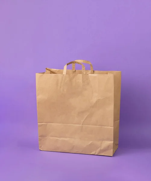 紫色の背景に大きな紙のショッピングバッグ 環境に優しいショッピングコンテナ — ストック写真