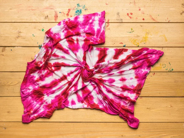 Ahşap bir masaya kravat boyası tişörtü ile boyadıktan sonra serilmiş. Boyama işlemi kravat boyası tarzında. Düz yatıyordu.