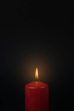 Siyah arka planda yanan parlak bir mum. Romantik ilişki kavramı.