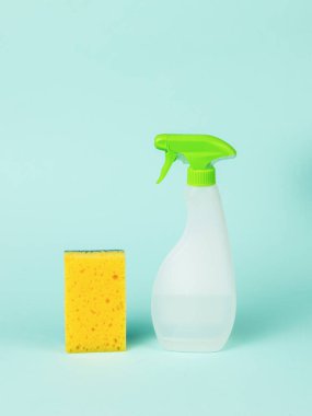 Üzerinde temizlik maddesi ve mavi arka planda köpük süngeri olan plastik bir şişe. Temizlik kiti.