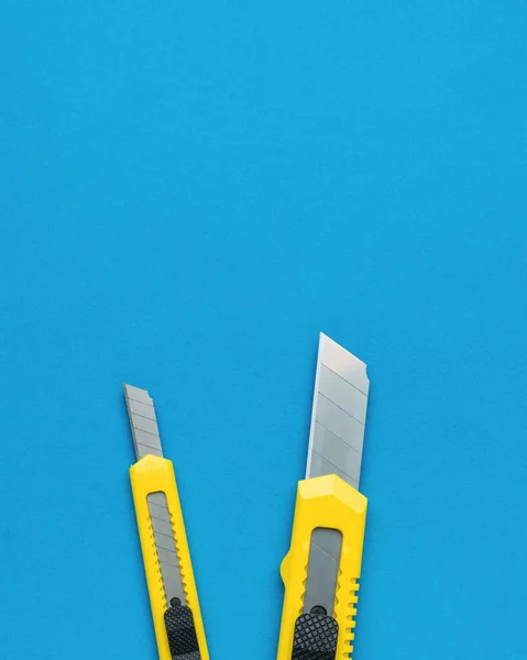 Two Bright Yellow Stationery Knives Blue Background Tools Creativity Education — Stock Photo, Image