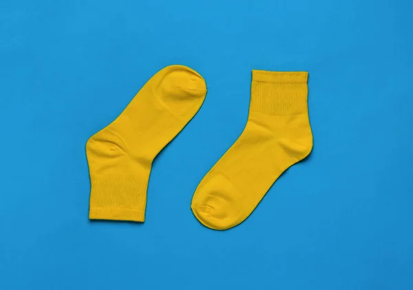 Par Calcetines Deportivos Color Amarillo Brillante Sobre Fondo Azul Brillante —  Fotos de Stock