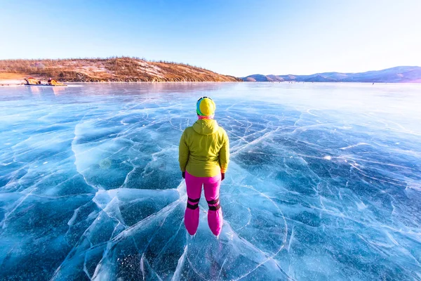 Pés close-ups de patins nas pernas Uma mulher vestida brilhantemente colorido no gelo azul do Lago Baikal — Fotografia de Stock