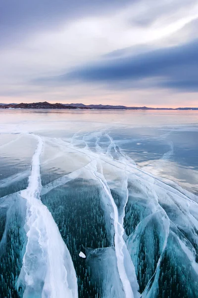 Grandes rachaduras no gelo azul liso claro do Lago Baikal ao pôr do sol. Sibéria Rússia — Fotografia de Stock