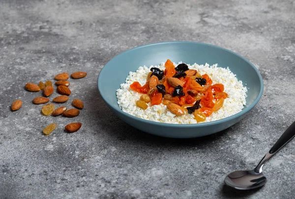 Gri arka planda kurutulmuş meyveli süzme peynir.