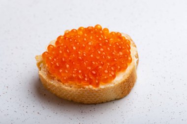 Arka planda kırmızı havyarlı sandviç.