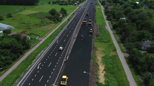 Rouleaux routiers construisant la nouvelle route asphaltée vue aérienne — Video