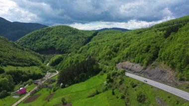Güneşli bir günde otoyolda arabalarla dağlarda trafik vardı.