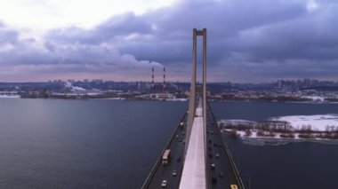 Nehir kenarındaki çöp yakma tesisi bacası. Büyük köprünün hava manzarasında şehir trafiği