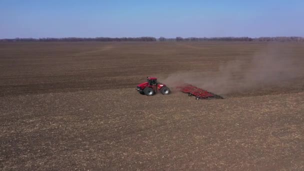 Kherson, Oekraïne - april 2022: Puffy Smoke from A Tractor with A Seeder Sowing In A Plowed Field. Zaaien tijdens vijandelijkheden in Oekraïne. — Stockvideo
