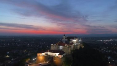 Yaz mevsimi hava manzaralı güzel kırmızı günbatımı ile geceleyin dağdaki Avrupa şatosu