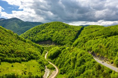 Bulutlu bir günde, dağ yolunda araba trafiği