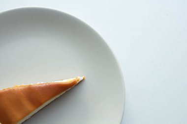 Üstünde karamel olan lezzetli bir dilim peynirli kek.