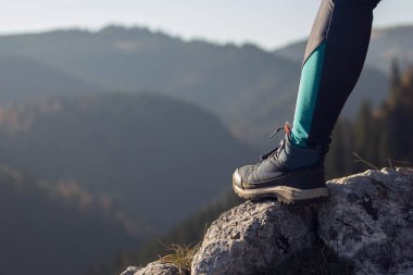 Womans leg on a monutain top watching the view