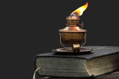 Really old oil lamp on a bible