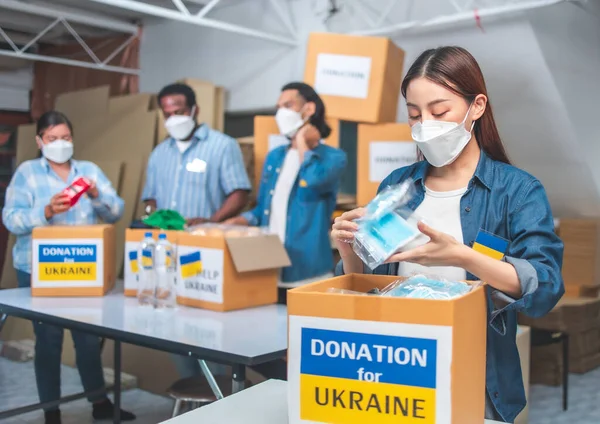 Afrikalı, Asyalı ve Asyalı bir grup gönüllü Ukrain 'de ihtiyacı olan insanlar için gıda bağışı hazırlıyor. İnsani yardım kavramı..