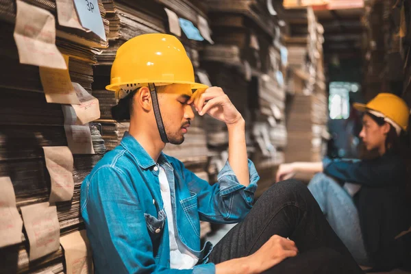 工場プランテーションに座っているアジアのビジネスオーナーは 仕事で試してみて真剣に感じます エンジニアや工場労働者ハードワーク ストレスを受けた感情 ストック写真