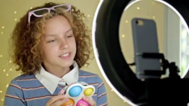 Blogcu kız evdeki stres önleyici oyuncaklara video eleştirisi yapıyor.