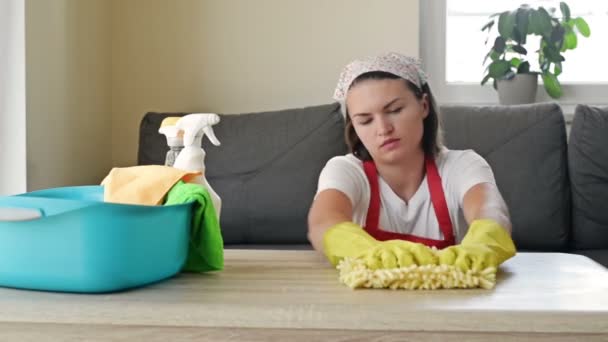 Η νεαρή νοικοκυρά κουράστηκε να διαβάζει. Υπερκόπωση γυναίκα που περιβάλλεται από προϊόντα καθαρισμού ανάπαυσης από την εργασία. Έννοια οικιακής εργασίας. — Αρχείο Βίντεο