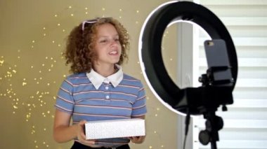 Genç blogcu bir kutuyu açıyor ve blogu için bir video kaydediyor. Abone ve arkadaşlarıyla sosyal ağlarda bir video blogcu kızın iletişimi.
