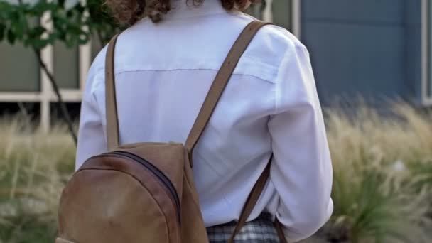 Εφηβικό κορίτσι με σακίδιο στους ώμους πηγαίνει σχολείο μετά τις καλοκαιρινές διακοπές. Πίσω στο σχολείο. Κοντινό πλάνο. — Αρχείο Βίντεο