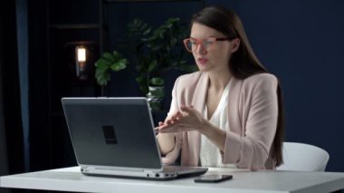 Başarılı iş kadını dizüstü bilgisayarla telefonda konuşuyor iş yerinde iş görüşmesi yapıyor, gülümseyen kadın CEO yöneticisi müşteriyle ya da danışmanlık yapan müşteriyle ofis masasında oturuyor..