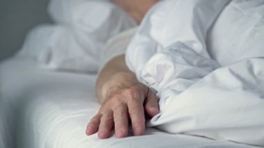 Hasta bir insanın elini tutan koruyucu eldivenli bir hemşirenin şefkatli eli. Aşk, şefkat ve destek. Yakın plan..