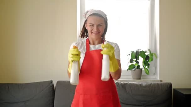 Stanco di lavoro noioso, la casalinga ha iniziato un gioco divertente con gli spruzzatori a mano. — Video Stock