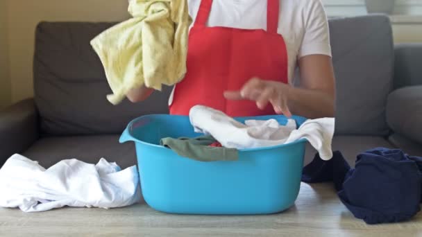 A dona de casa se prepara para lavar itens delicados. A mulher está segurando uma bacia de lavanderia. — Vídeo de Stock