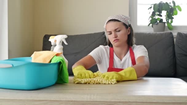 A jovem dona de casa está cansada dos trabalhos de casa. Mulher sobrecarregada rodeada de produtos de limpeza que descansam do trabalho. Conceito de trabalho doméstico. — Vídeo de Stock