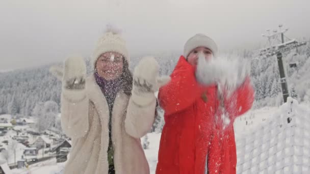 年轻女人和她十几岁的女儿一起玩雪。快乐的家庭时间。寒假. — 图库视频影像