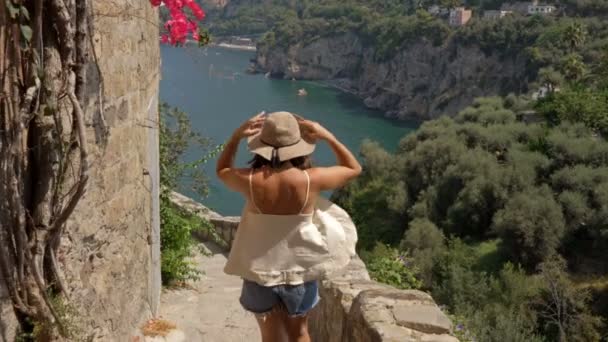Νεαρή τουρίστρια θαυμάζει την όμορφη θέα της θάλασσας και των βουνών. Καλοκαίρι στην Ιταλία. — Αρχείο Βίντεο