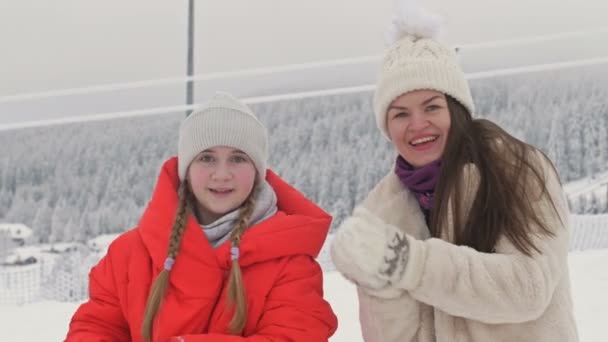 Rodinný portrét mladé ženy se svou dospívající dcerou na pozadí zimní krajiny. — Stock video
