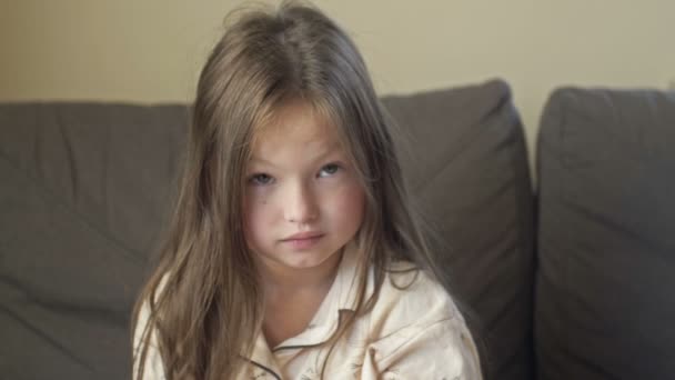 Potret seorang gadis marah 6-7 tahun setelah tidur di piyama. — Stok Video